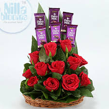 A beautiful presentation of dairy milk chocolate and red roses in a basket