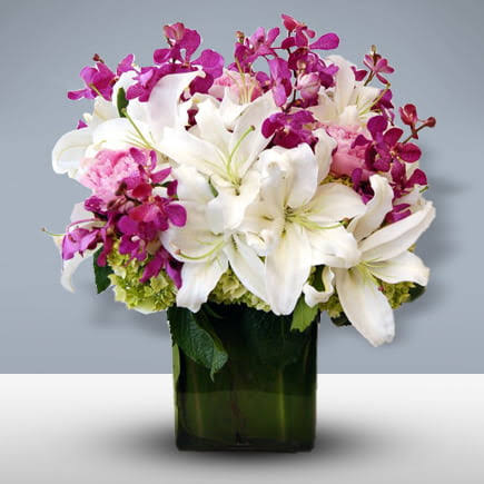 Attractive Purple orchids with White Lilies Vase arrangement