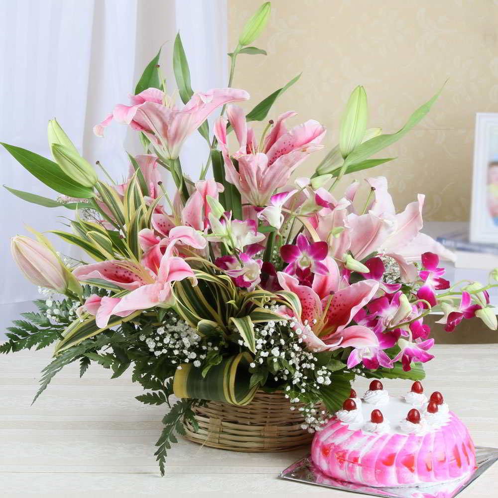 Charming Floral arrangement of Pink Lilies and Orchids with Strawberry Cake.