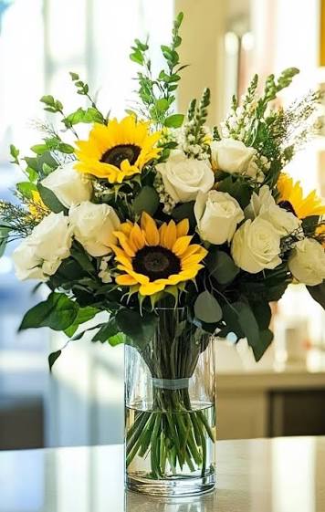 Elegant white roses and sunflowers in a vase.