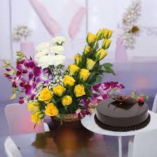 Exotic multicolored flower arrangement with chocolate cake.