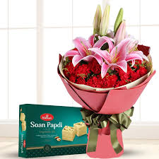 Magica Red Carnation and Pink Lilies Bouquet with Tempting Soan Papdi