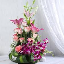 Pink Lilies blend pink roses and blue orchids in baskets.