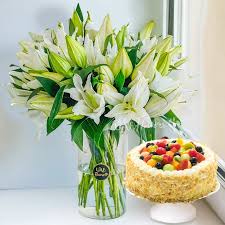 Premium White lilies in Vase with sumptuous fresh fruit cake