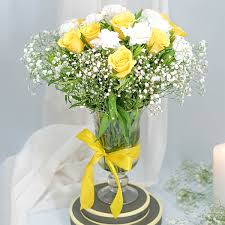 Yellow roses and white carnations fused in a glass vase.
