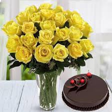 Yellow roses in a vase with chocolate cake.